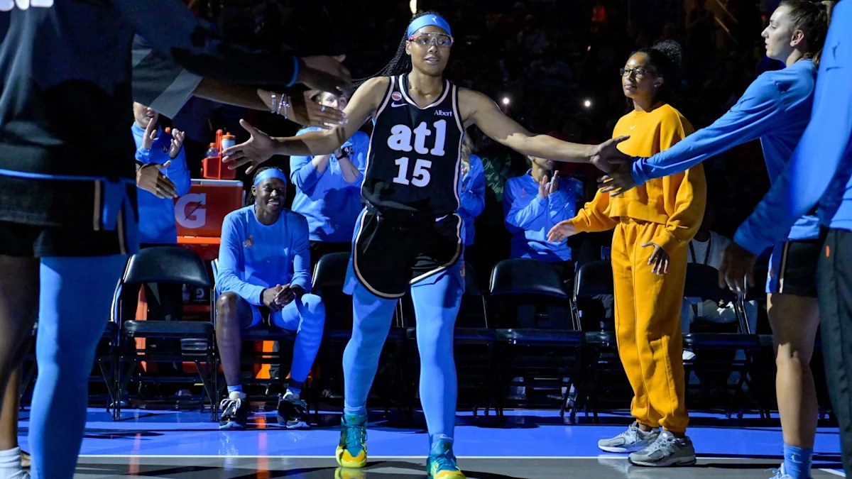 Atlanta Dream player in a black atl No. 15 jersey high-fives teammates during pregame introductions